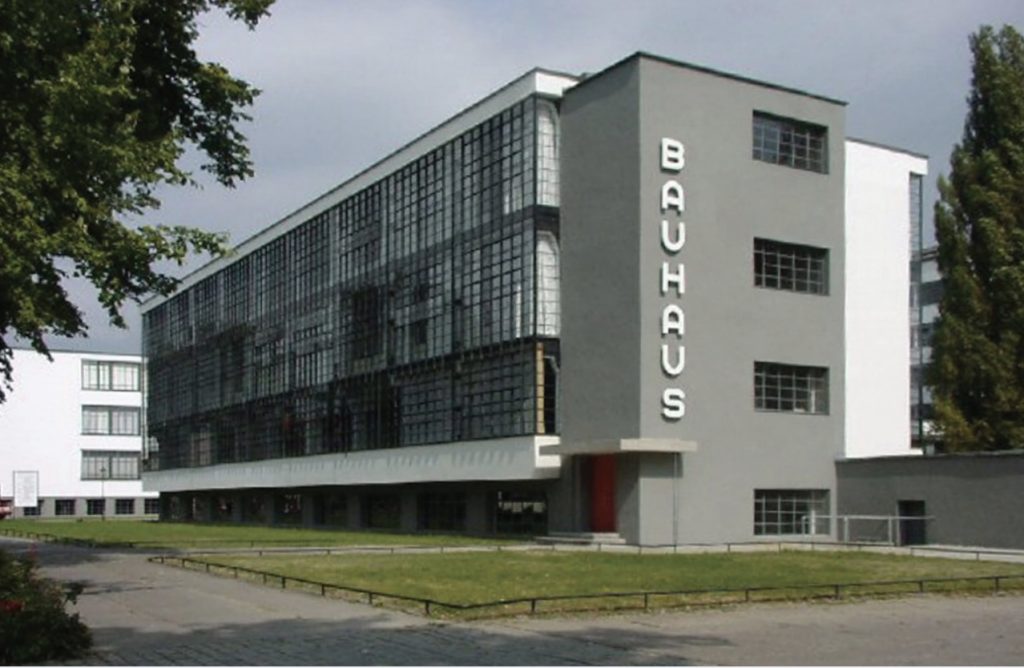 Photo of green-grey rectangular Bauhaus building in Germany.
