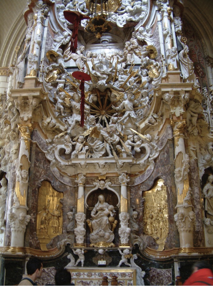 Photo of altar with elaborate carvings and gilding lit by natural sunlight.
