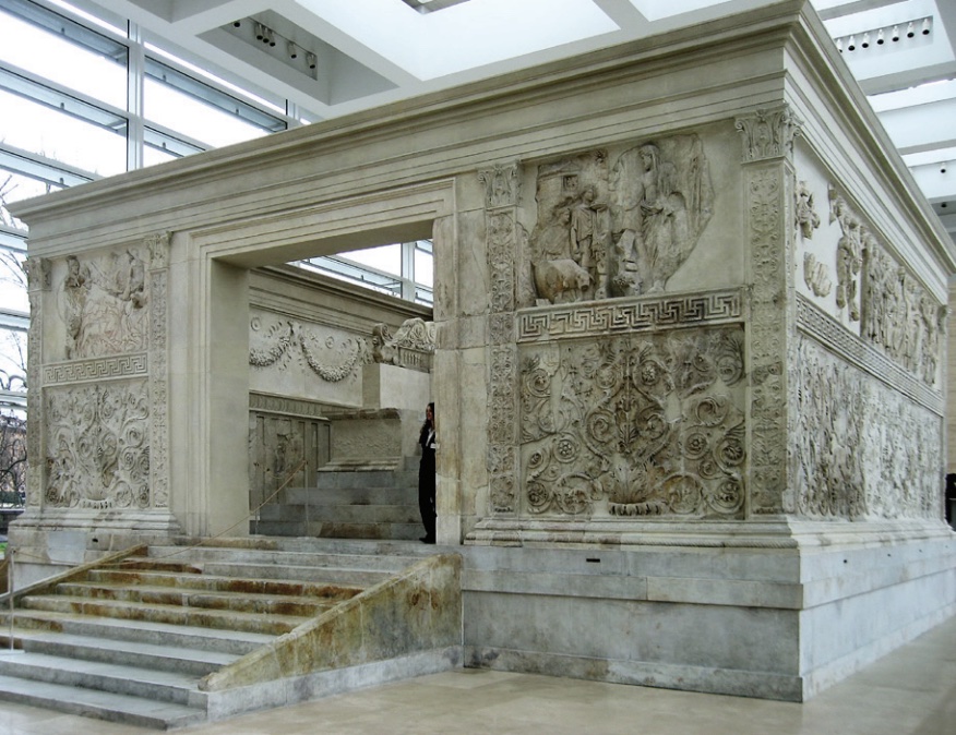 Photo of stone altar sculpted with images and messages on walls and steps leading up to entryway.