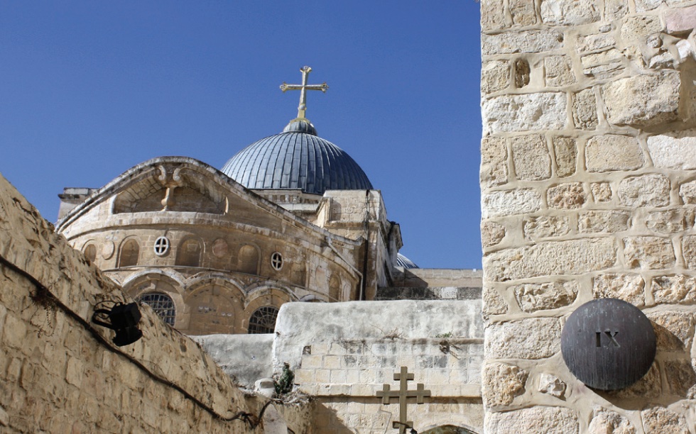 Photo of Church of the Holy Sepulchre with blue dome and large cross at top.