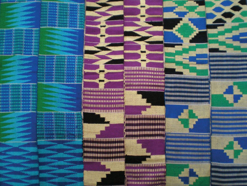 Photo of a cloth weaving of silk and cotton in hues of green, blue, purple, black, and tan.