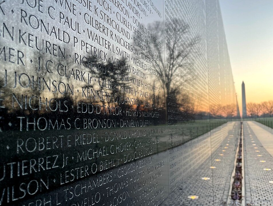 Vietnam war memorial wall with Washington Monument in the distance.