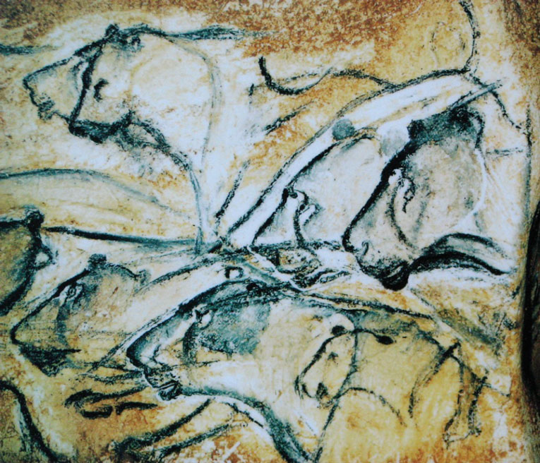 Photo of cave drawings of lions on cave wall.
