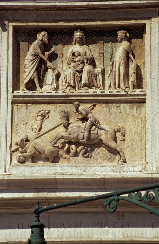 Image of St. George relief by Pietro da Salo. Shown is a high relief of Madonna with Child to her left is St. John the Baptist and to her right is St. Catherine. The bottom part of the relief is St. George fighting the Dragon.