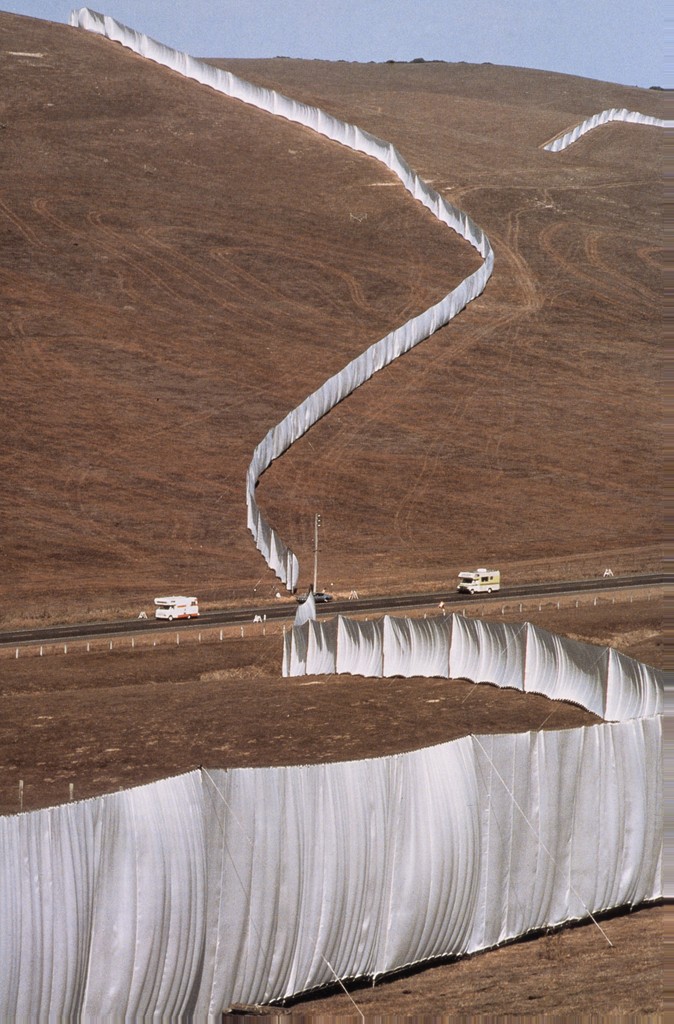 Image of Running Fence by Christo and Jeanne-Claude. 24.5 mile veiled fence that extended through northern California. The white panels were made of nylon fabric that hung from steel cables supported by steel poles.