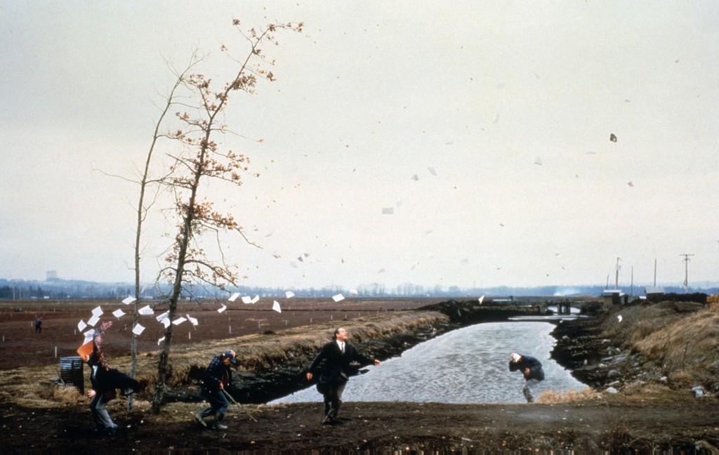 Image of A Sudden Gust of Wind (After Hokusai) by Jeff Wall. Photograph of people caught in a gust of wind with papers being swept away.