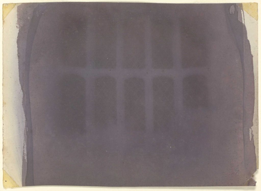 Image of The Oriel Window by William Henry Fox Talbot. One of the earliest photographs in existence shows the diamond pane from the window in Talbot's home. Paper negative.