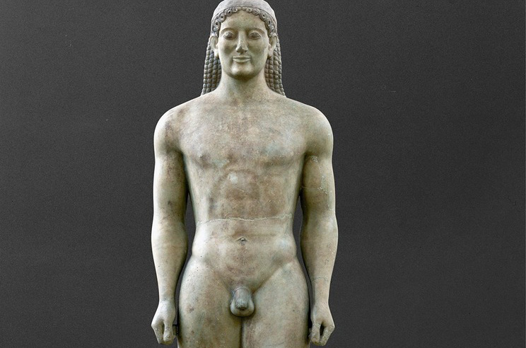 Image of sculpture of a nude young boy, both hands in fists and firm stance.