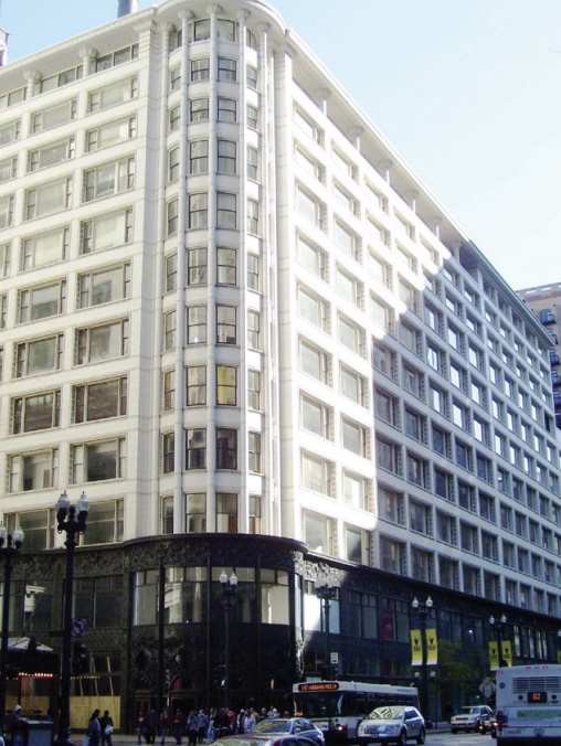 Photo of corner of city building with several stories.