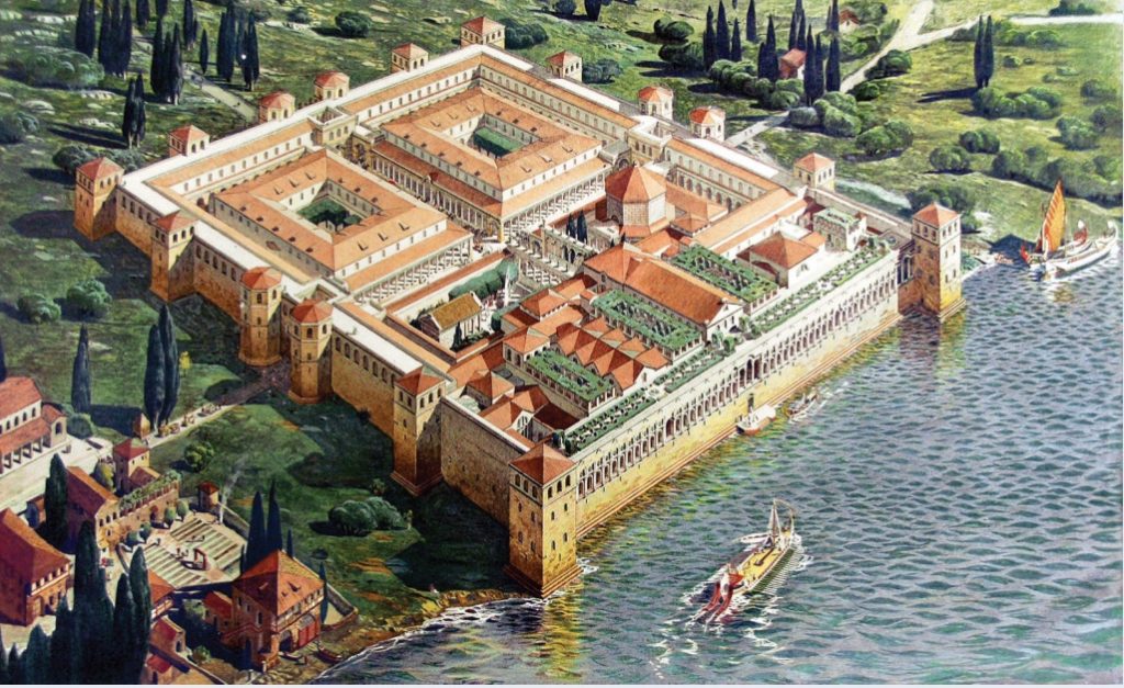 Illustration of a compound abutting the sea with tall walls surrounding several precincts and watchtowers.