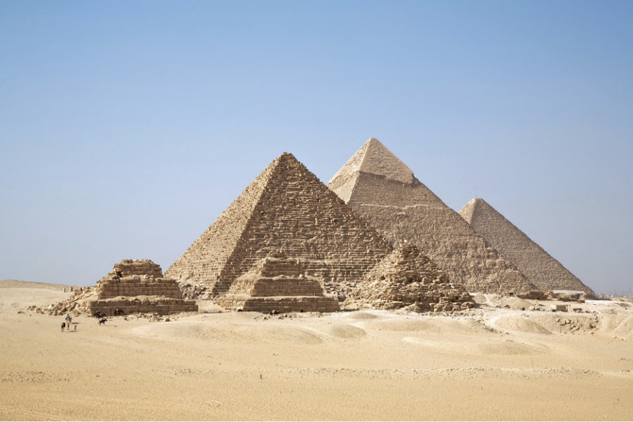 Photo of the Pyramids of Giza in Egypt among sandy landscape.