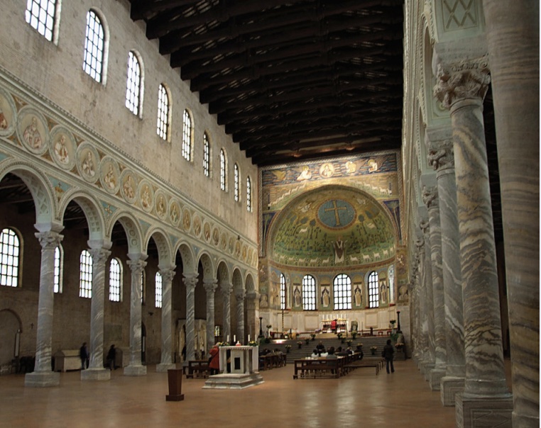 Photo of interior of basilica with colorful walls and columns along sides.