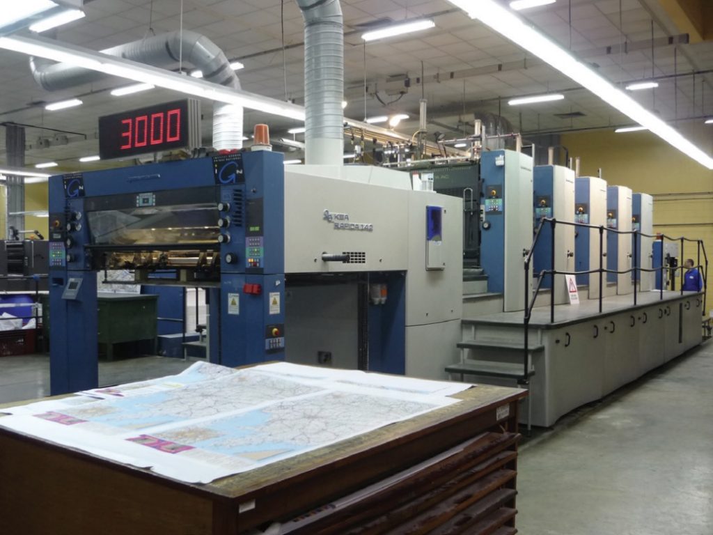 Photo of offset press in inside large lab space.