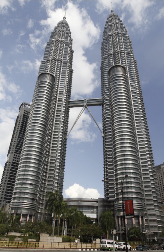 Photo of two twin silver and round towers with walking bridge connecting them in middle.