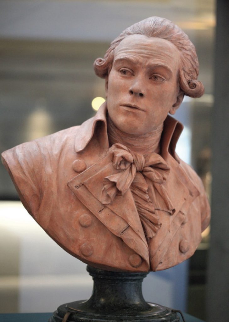 Photo of bust of man in suit with tied scarf and wig.