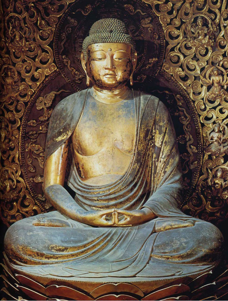 Photo of golden-colored statue of Buddha in meditative pose.