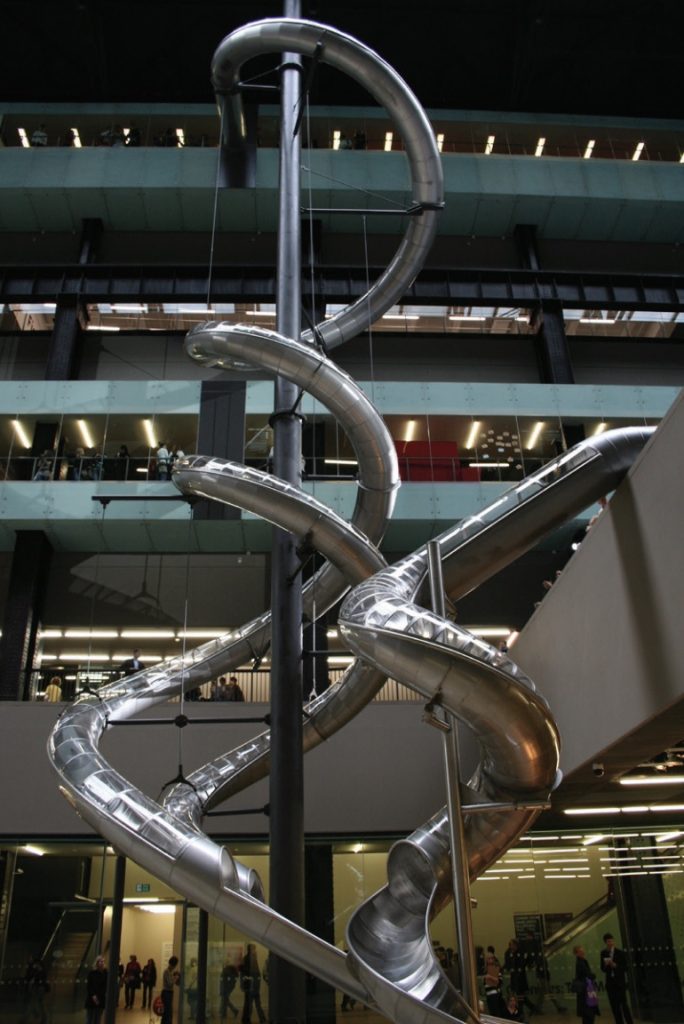 Photo of an enclosed metal slide that goes down several stories.