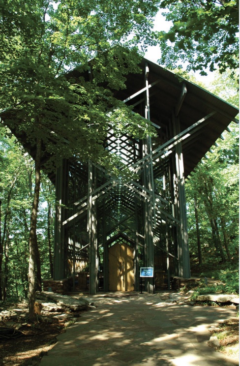 Photo of cathedral built in dense forest with simple, local wood materials and many diagonal beams.