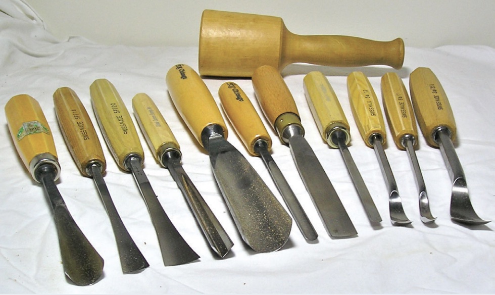 Photo of several woodcarving tools laid out on table.
