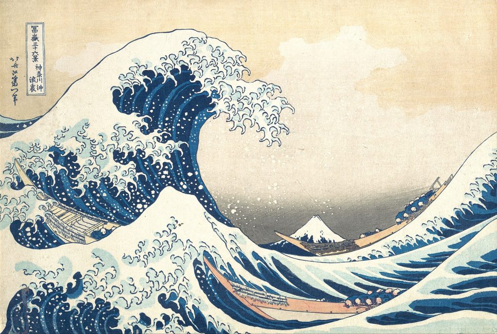 Image of a great blue wave that is cresting over a boat in a stormy sea.