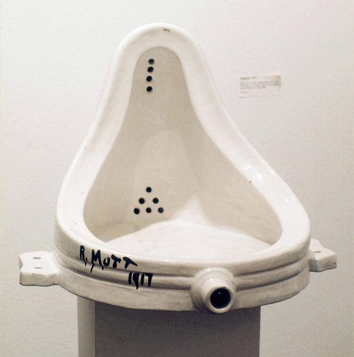 Image of reproduction of Fountain by Marcel Duchamp. Glazed ceramic urinal wit the signature R.Mutt on its side.