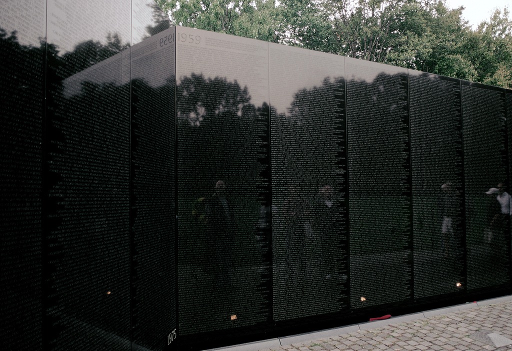 Large polished black marble walls engraved with the names of Vietnam War service members that fought in the war.