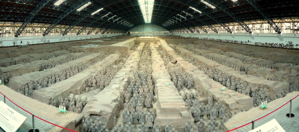 Image of Terracotta Warriors from the mausoleum of the first Qin Emperor of China: Qin Shihuang. Rows of Terracotta warriors all lined up, with horses and some carriages as well.