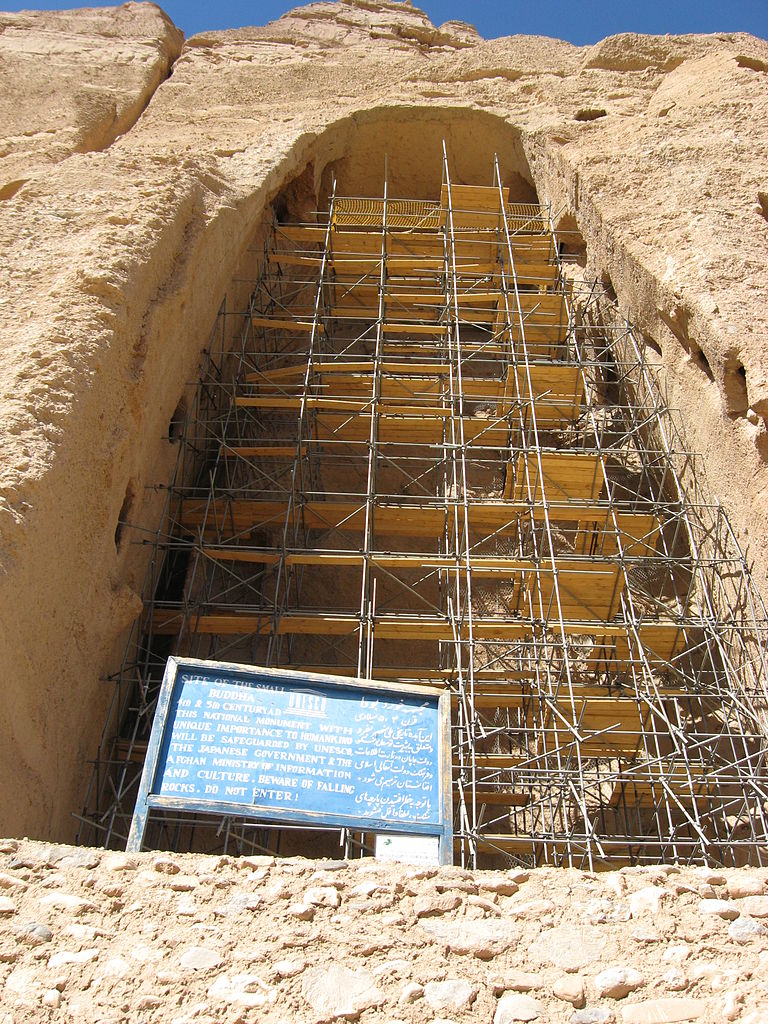 A photo of an empty cave where the statue once stook. Inside the cave is a tower of scaffolding.