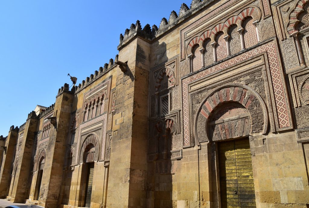 Exterior of the Great Mosque at Cordoba showing horseshoe arches in detailed mosaics.