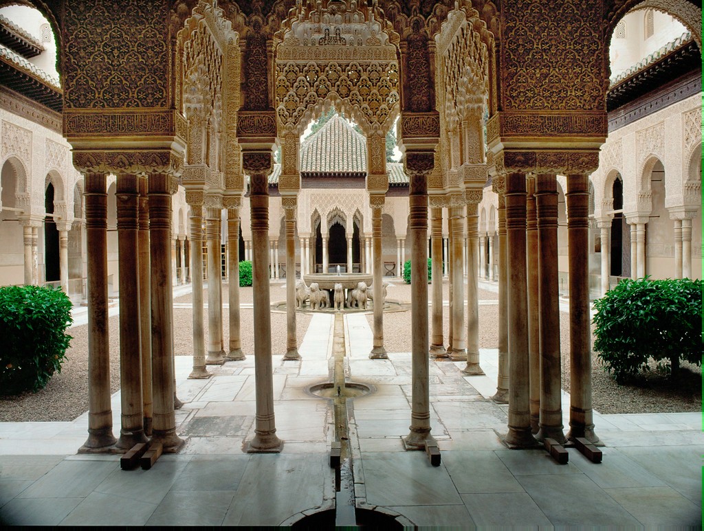 Photo of a courtyard with elaborately carved pillars, and a fountain.