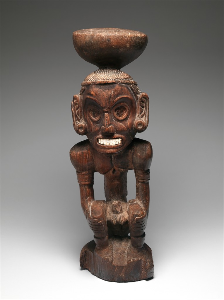 A woos and shell statue of a god of the Dominican Republic He is shown nude with adornments, and a bowl-shaped-figure on his head.