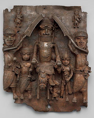 A brass sculptured panel of brass showing a ruler and his court.
