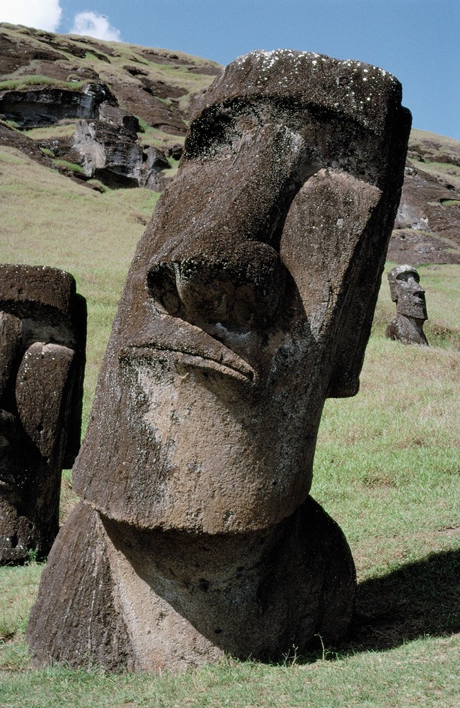 Image of Moai statues on s hilldie. Large stone statues with human-like heads.