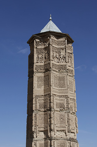 a star-shaped tower with elaborate script carved into its panels.