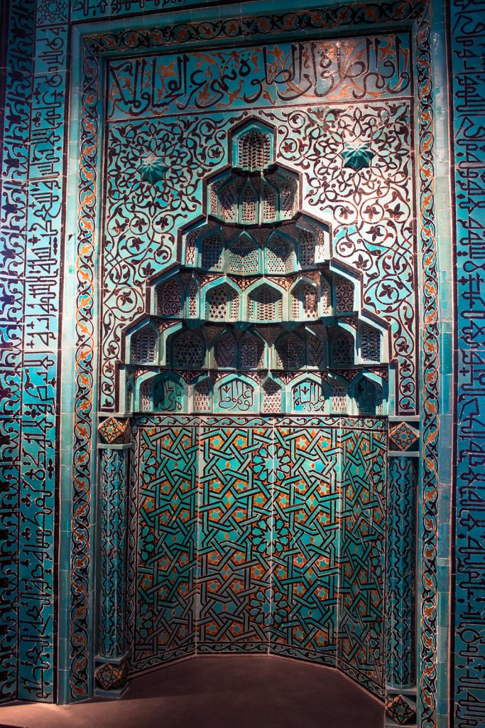 Details of the mosaics lining a cutout arch in a wall making the prayer niche.