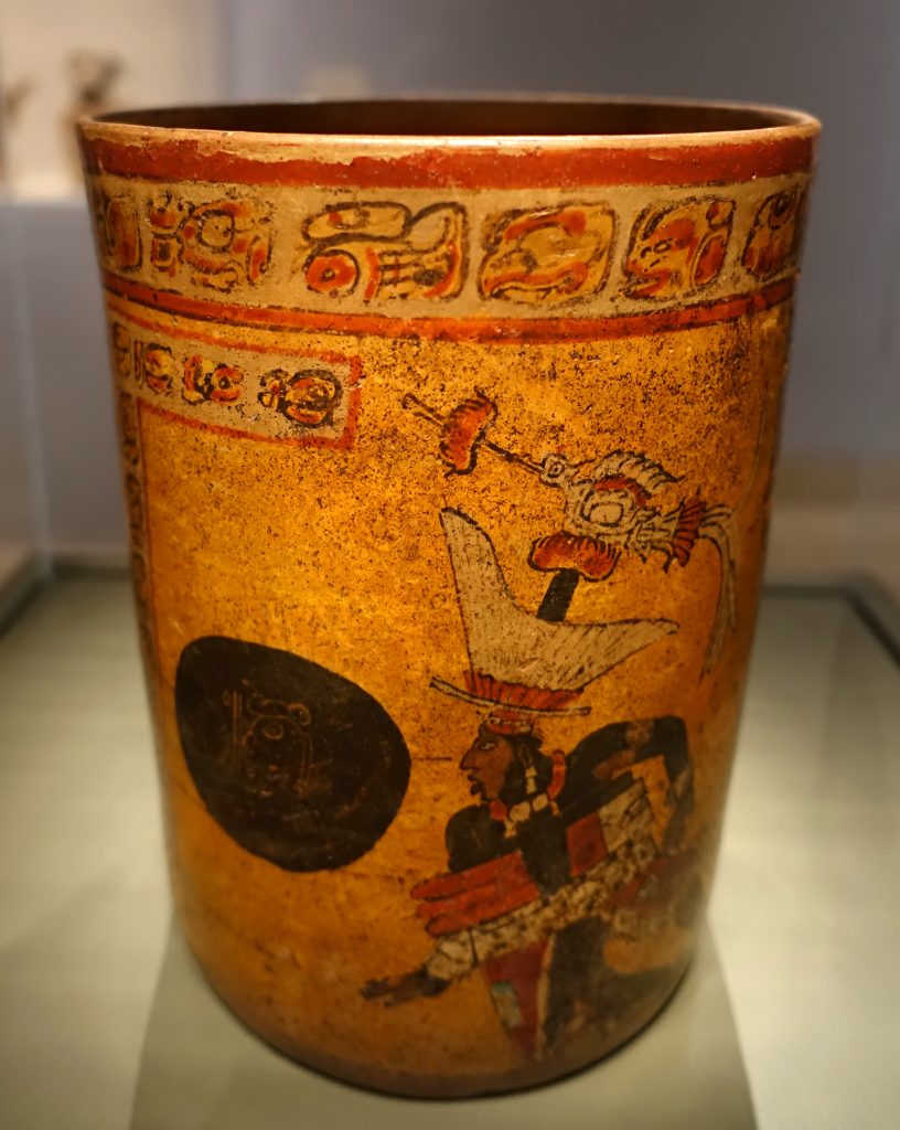 Photo of an ancient cylindrical vessel depicting a Mayan ball game scene.