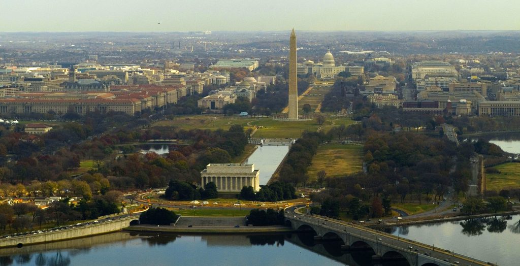 Aerial view of the National Mall, Washington D.C. showing buildings, like the Washington Monument, Lincoln Memorial, and the Capitol with Greek influence in their architecture.