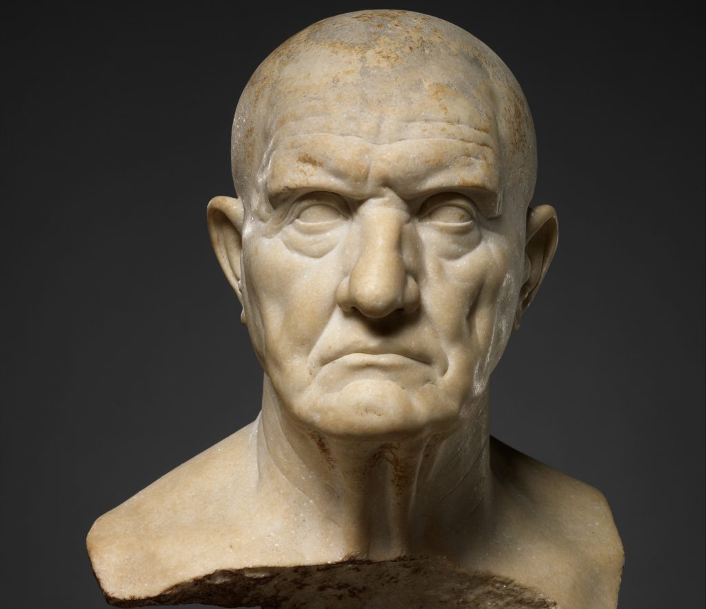 Image of marble bust of a man. Depicted with a serious/strong face.