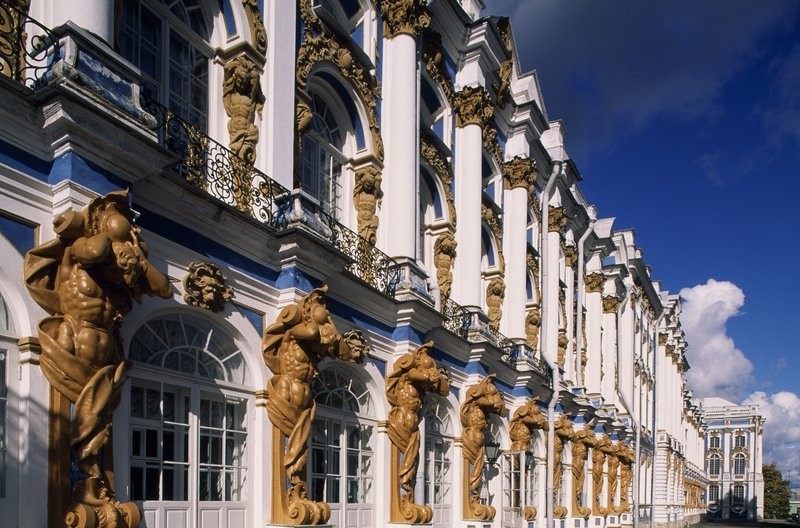 Photograph of facade of a large white palace with many windows.