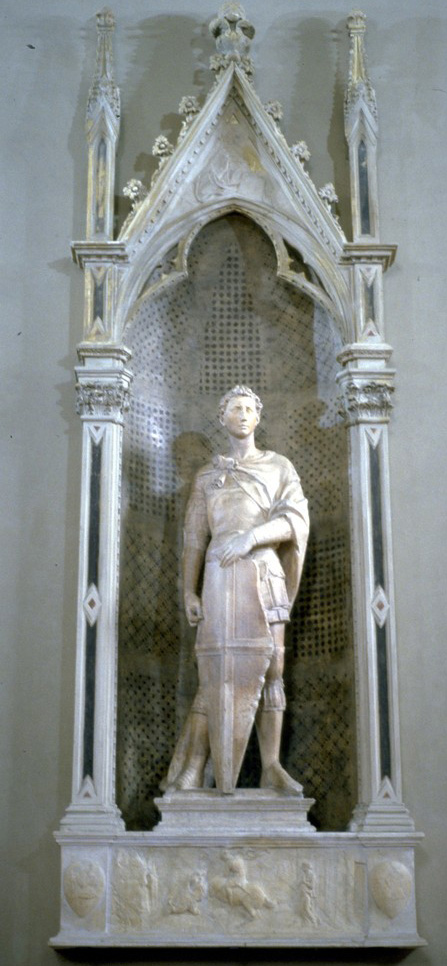 Sculpture by Donatello of man in robes inside an archway within a wall.