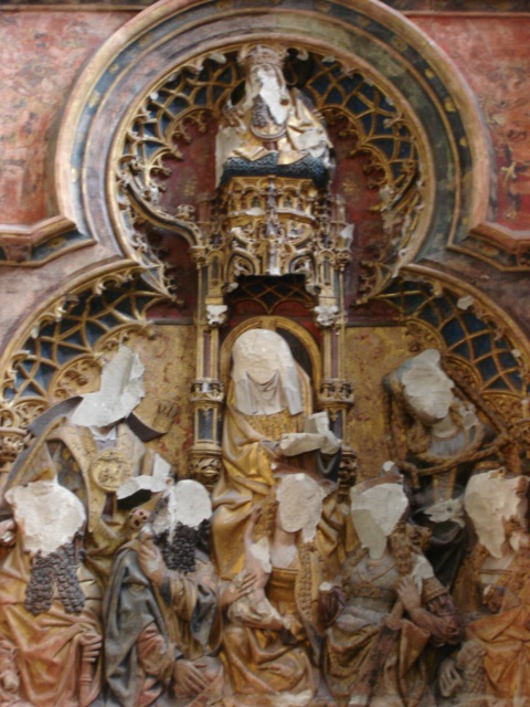 Alterpiece with relief sculpture, all of the faces have been broken off.