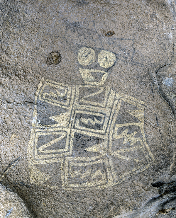 Photo of a boulder with rock drawings.