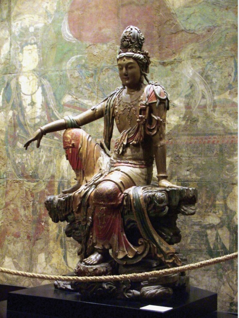 Photo of sculpture of a bodhisattva sitting on platform.