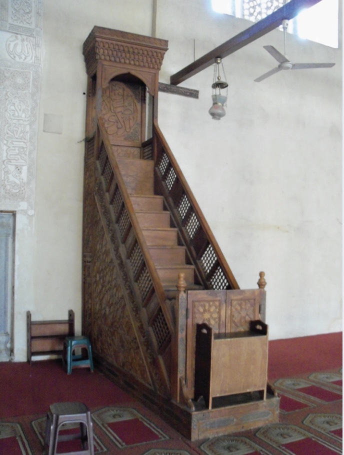 Photo of a wooden minbar or pulpit in an Islamic center with stairs.