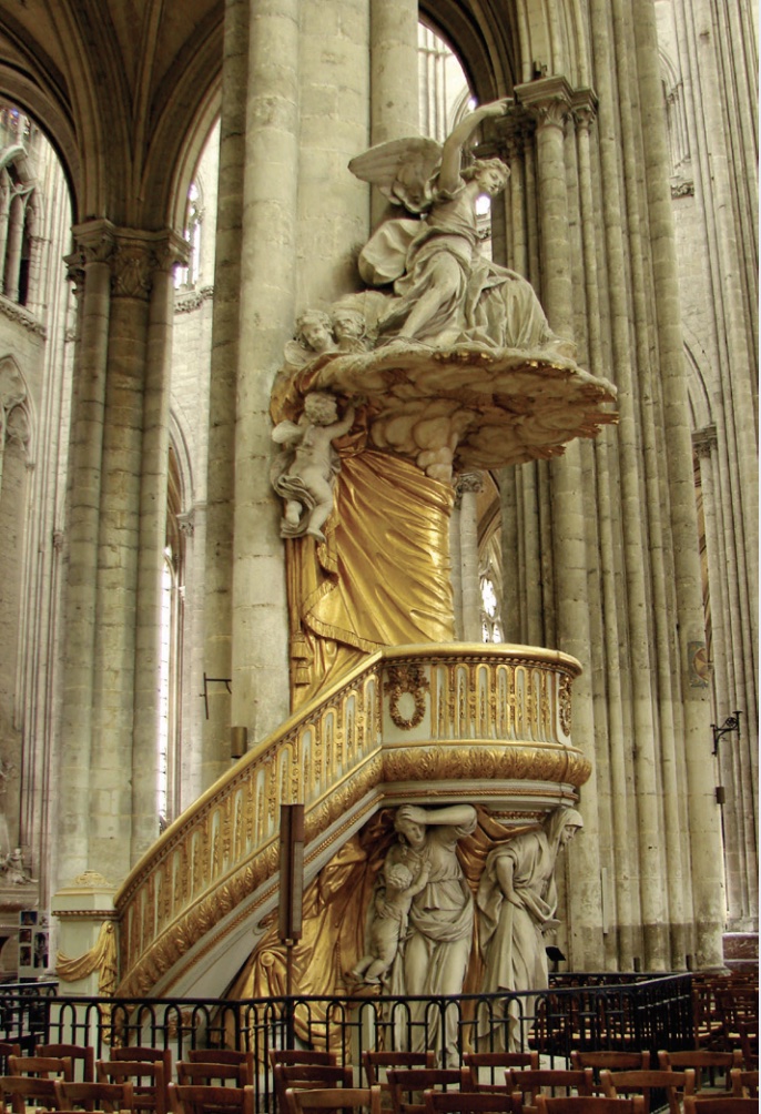 Photo of ornate gold pulpit with spiral staircus and sculptures above and below in cathedral.