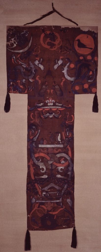 Photo of t-shaped swath of fine red silk with mythological images.