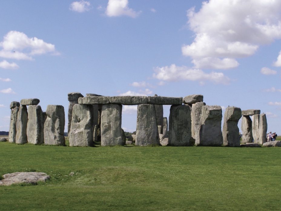 Photo of Stonehenge, showing a circle of giant boulders standing up right with some placed along top.